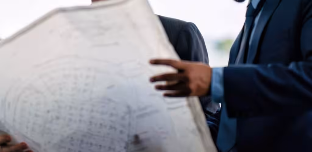 An engineer holds up the design plans for a tank