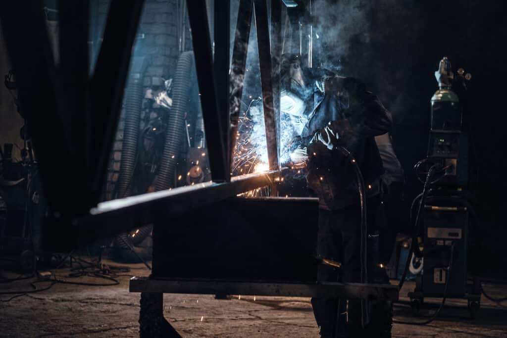 Worker welding steel pieces together