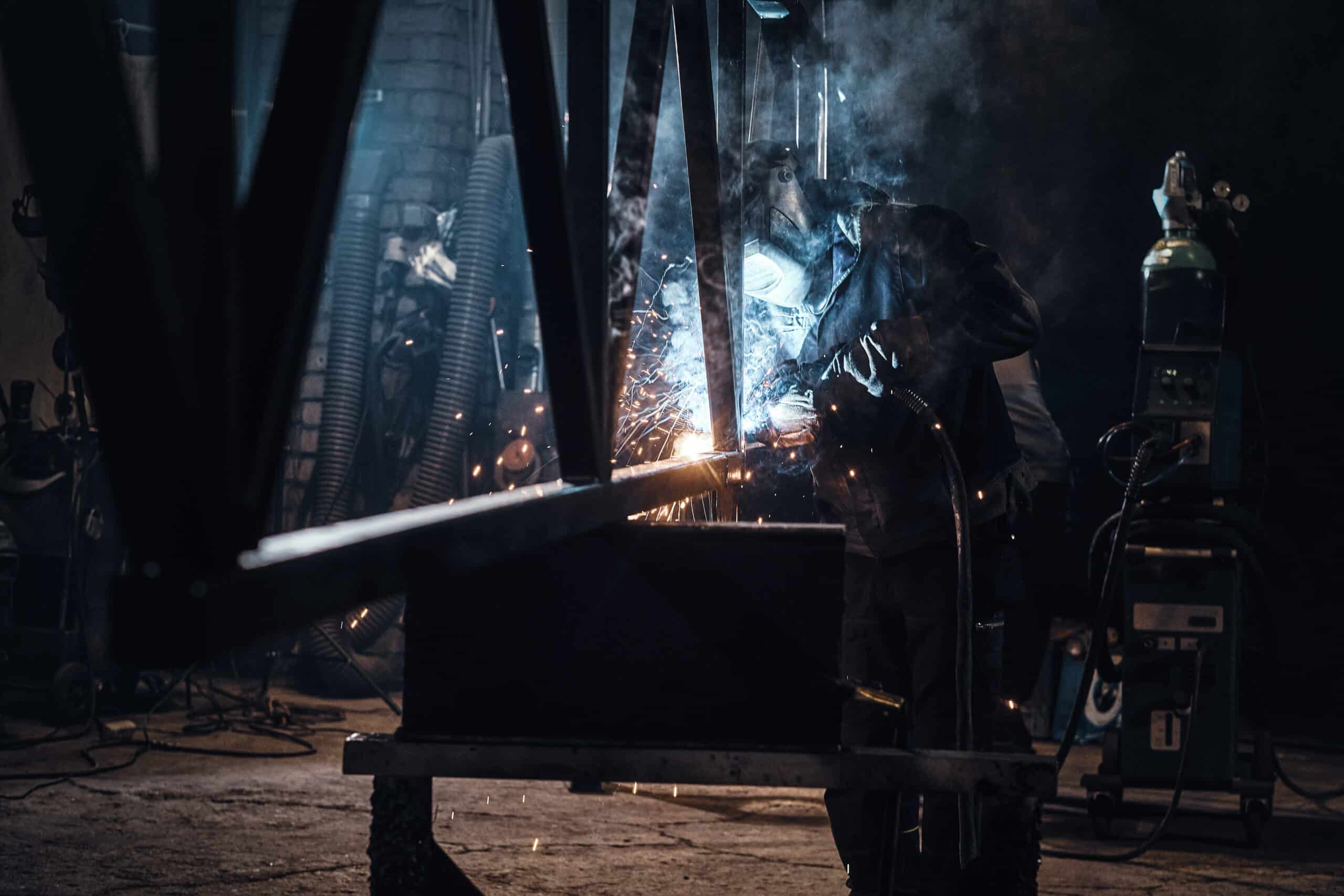 Welder sparks in dark workshop